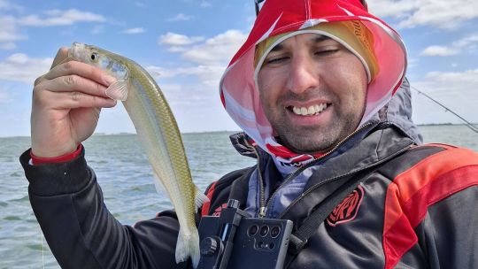 Persona pescando en un lago o río de Argentina durante un día despejado