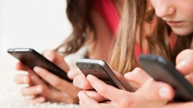 Gráfico de encuesta sobre percepción de riesgos para menores en redes sociales, con un celular de fondo.