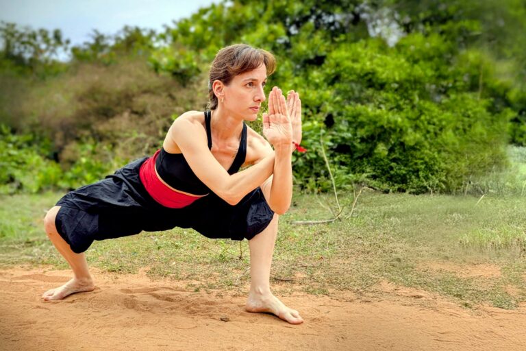 Persona realizando una postura del arte marcial Kalaripayattu en un espacio de práctica.