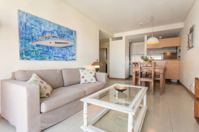 Persona revisando documentos de una compraventa de inmueble junto a un teclado y una taza de café.