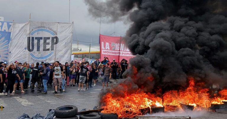 Manifestantes en una protesta con carteles en una avenida de Buenos Aires.
